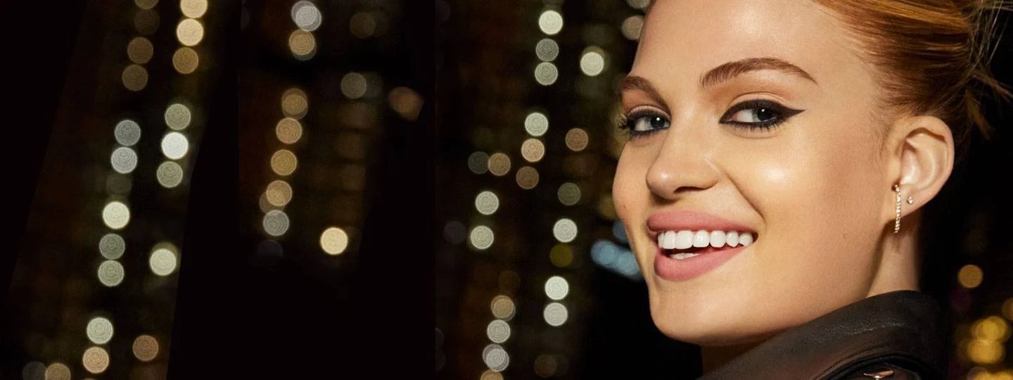 Kvinne smiler - bylys i bakgrunnen